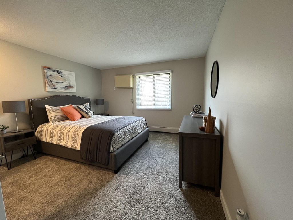 a bedroom with a bed and a desk and a window