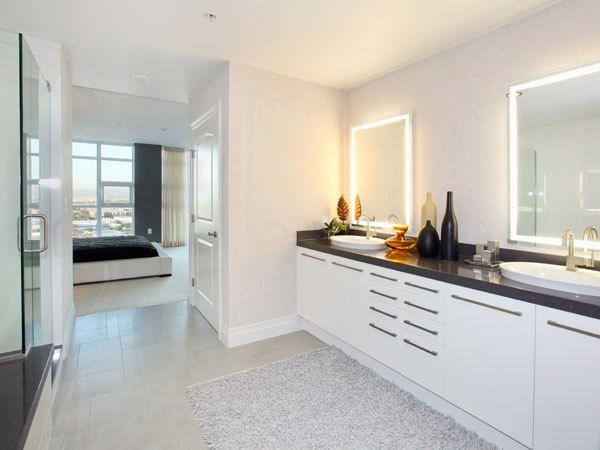 A modern bathroom with a large mirror and a vanity with a sink.