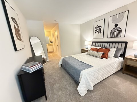 A bedroom with a large bed and a mirror on the wall.