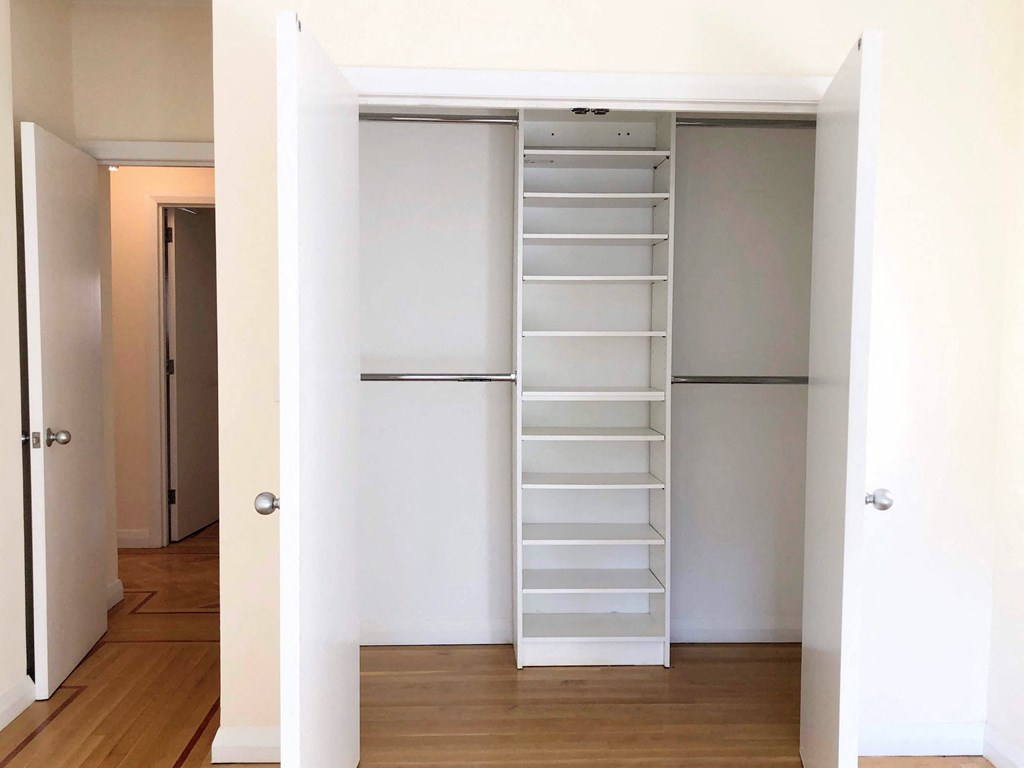 a bedroom with a medium sized wardrobe and a large closet