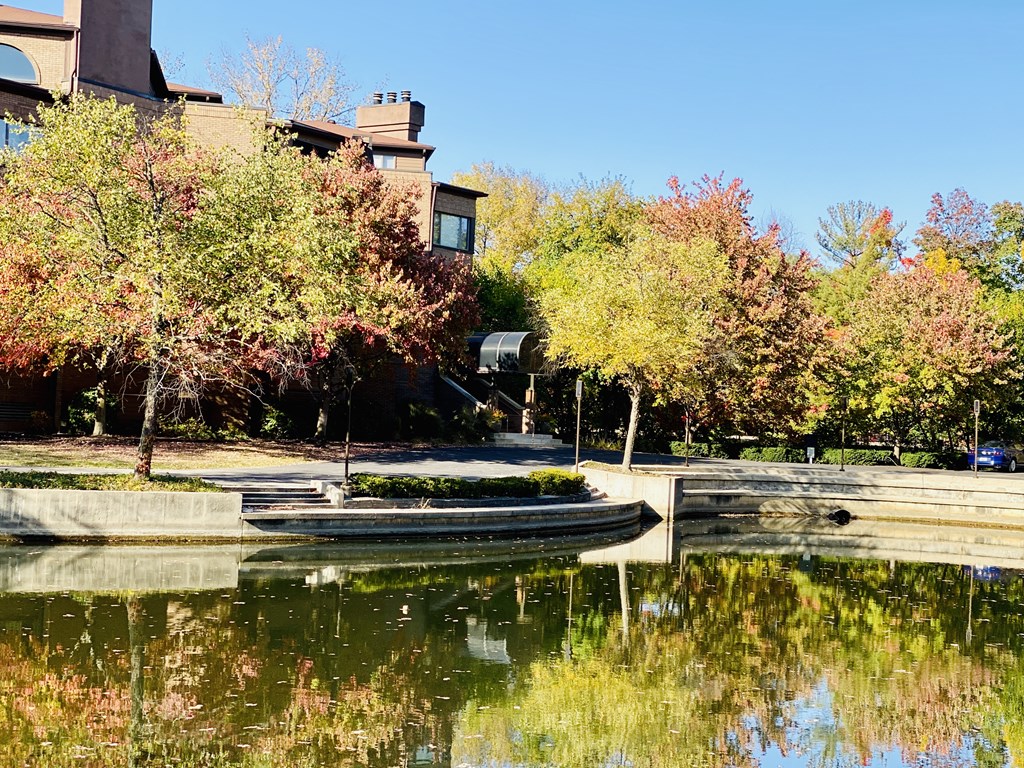 a pond with a boat in front of a building
