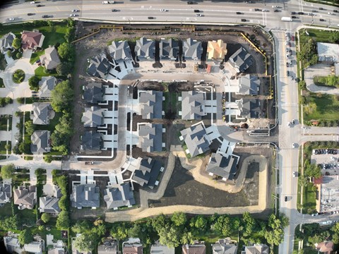 A bird's eye view of a residential area with a large open space in the middle.