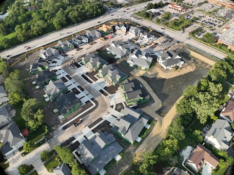 A bird's eye view of a residential area with houses and a road.