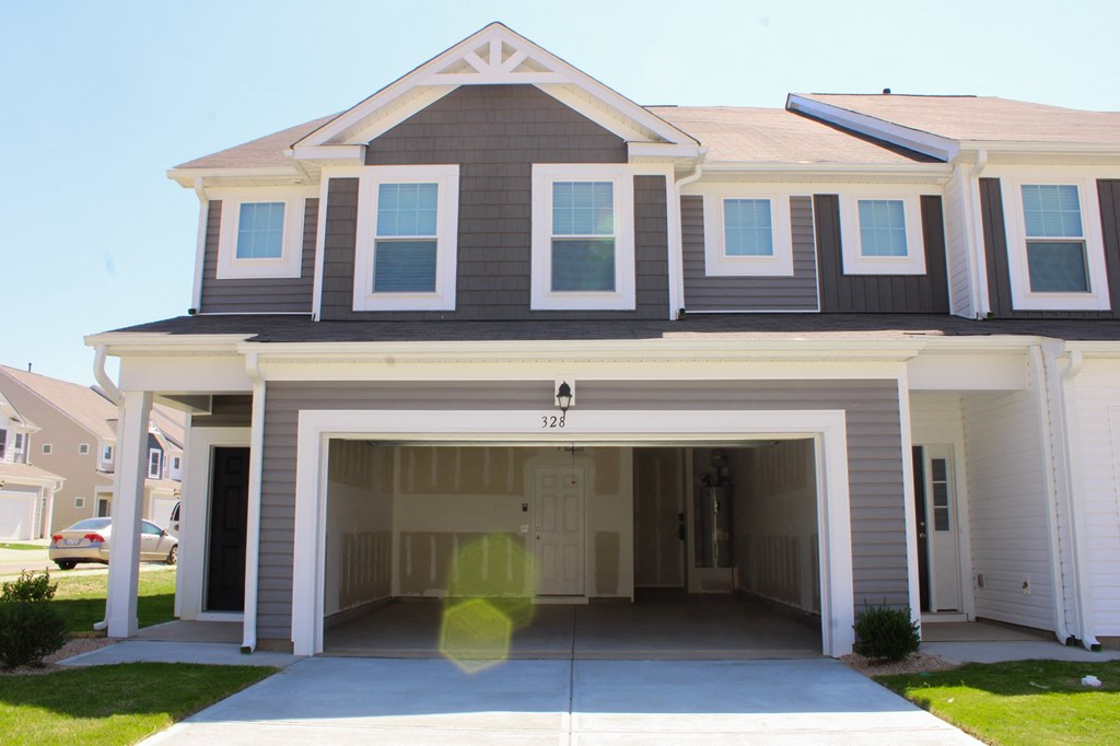the front of a house with a garage door open