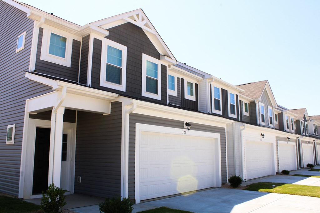 a row of houses with white garage doors