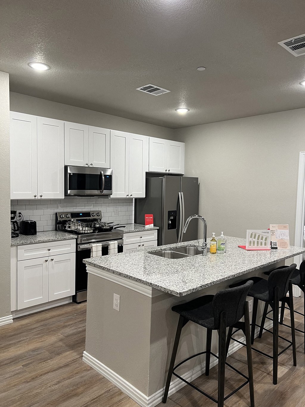 a kitchen with a granite counter top and white cabinets
