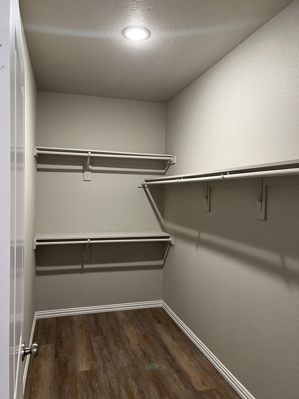 an empty garage with empty shelves and a wood floor