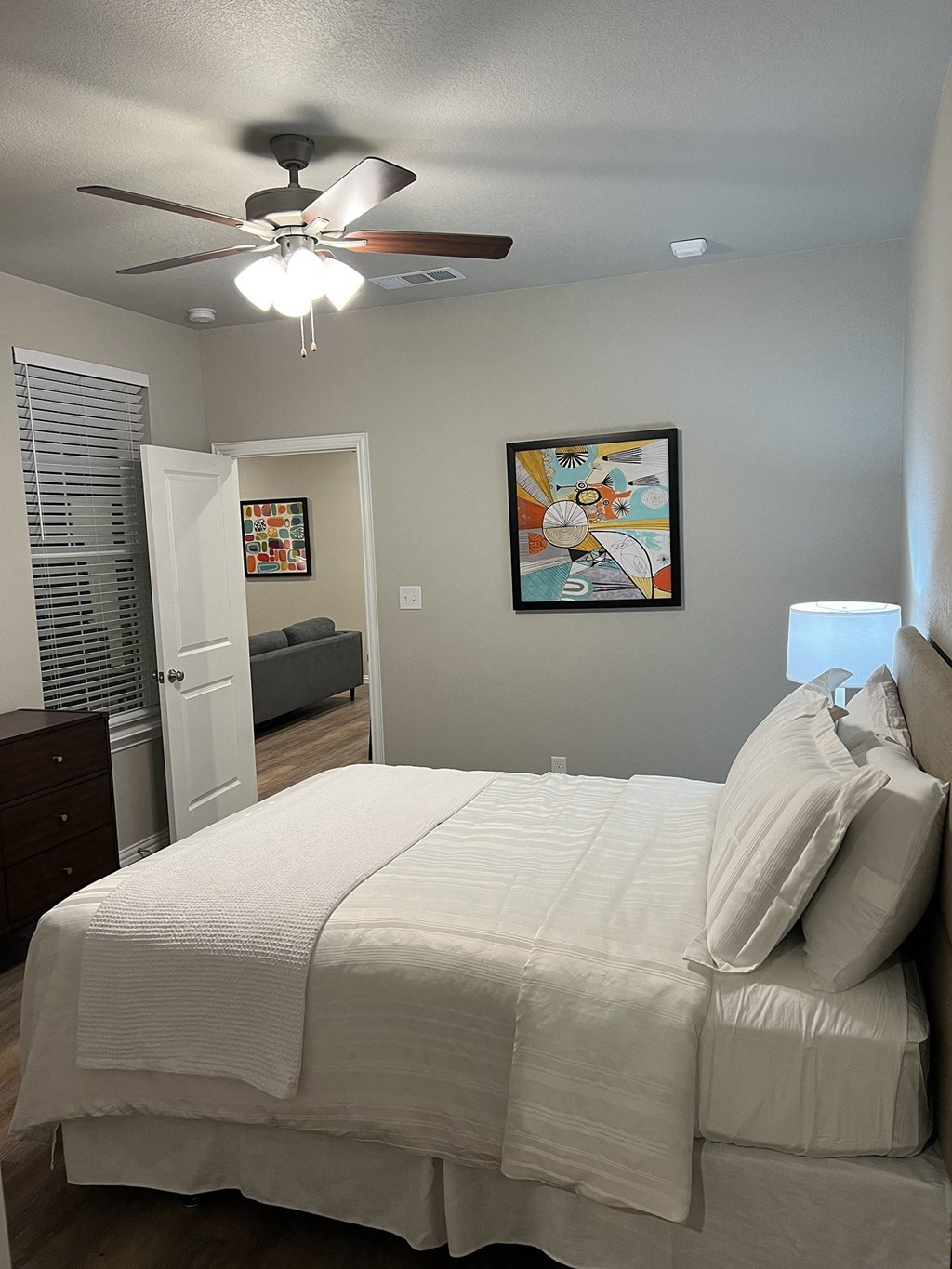 a bedroom with a large white bed and a ceiling fan
