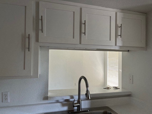 a kitchen with white cabinets and a sink