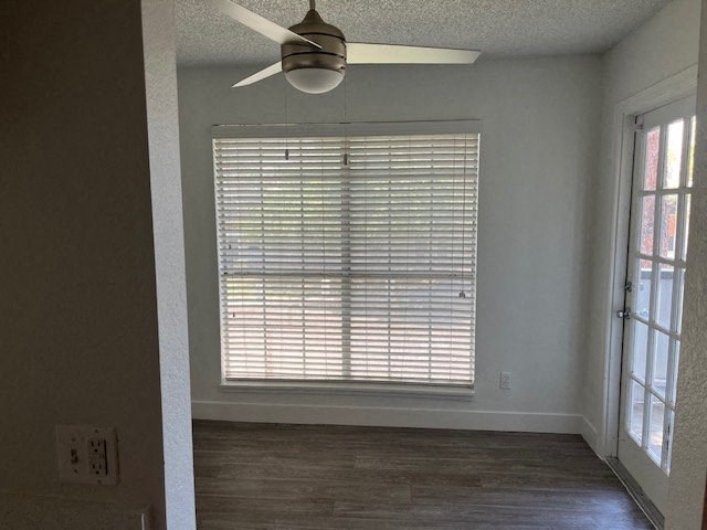an empty room with a large window and a ceiling fan