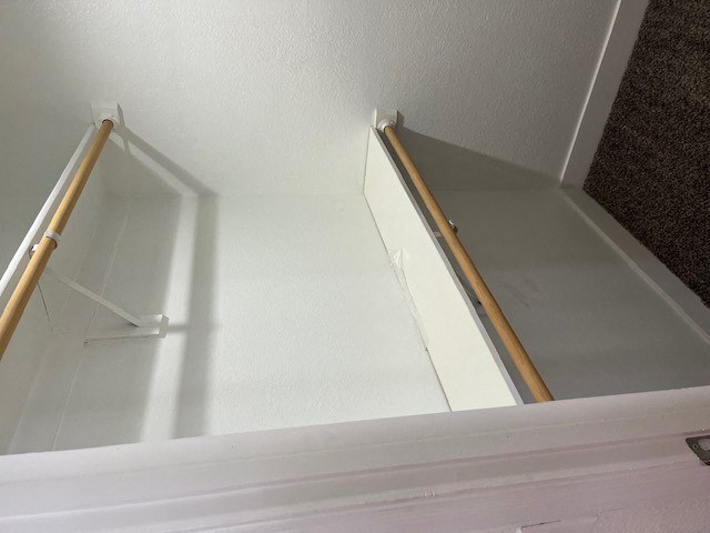 a room with a white wall and a white door with a wooden handle