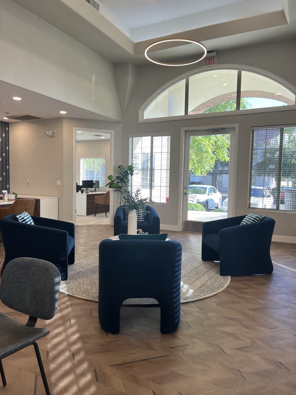 a lobby with blue chairs and tables and large windows