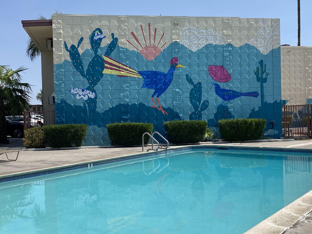 a mural of peacocks on the side of a pool
