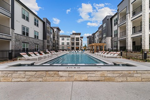 A swimming pool in the middle of a residential area surrounded by buildings.