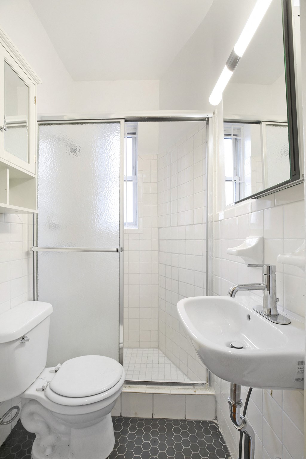 a white bathroom with a shower toilet and sink