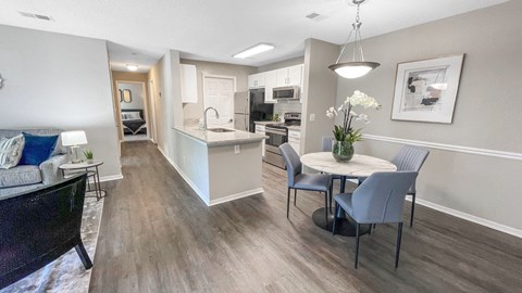 a renovated living room and kitchen with a table and chairs