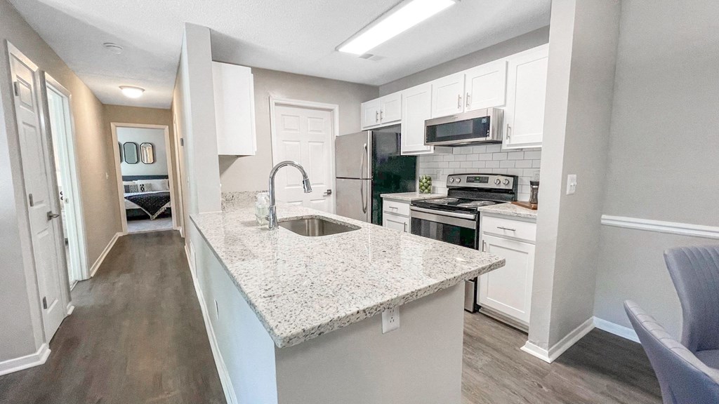 1 Park Central Apartments, Peachtree Corners, Georgia cozy kitchen with white cabinets and a granite counter top