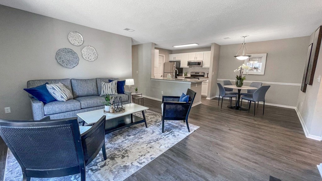 1 Park Central Apartments, Peachtree Corners, Georgia a living room with a couch table and chairs and a kitchen in the background