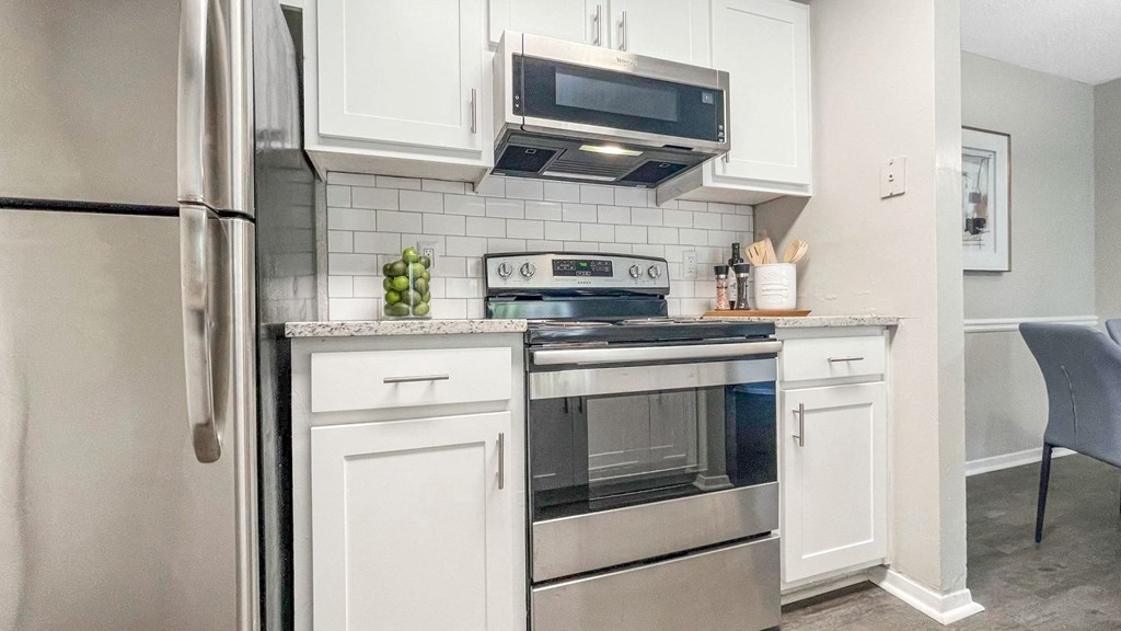 1 Park Central Apartments, Peachtree Corners, Georgia cozy kitchen with white cabinets and stainless steel appliances
