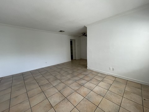 the living room and dining room of an empty house with tiled floors