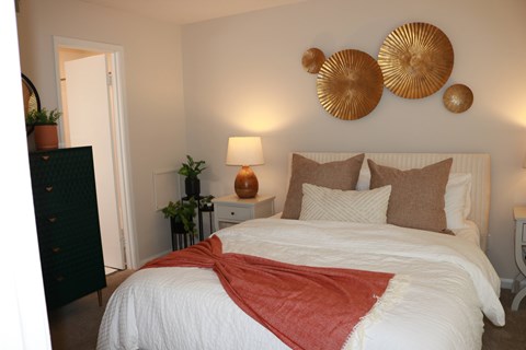 A bedroom with a large bed and a red blanket.