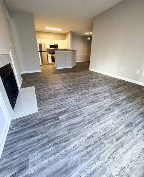 A living room with a grey floor and a television on the left side.