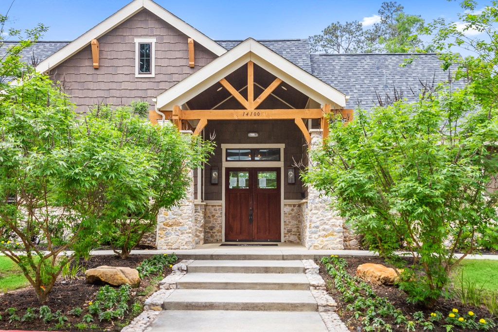 the front of a house with a wooden door and stone facade