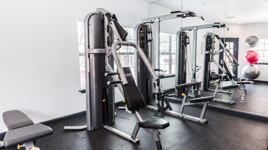 a gym with cardio machines and weights on the floor