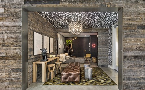 A modern living room with a stone wall and a patterned ceiling.