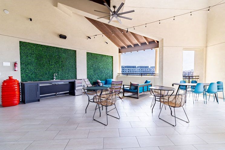a restaurant with tables and chairs and a ceiling fan