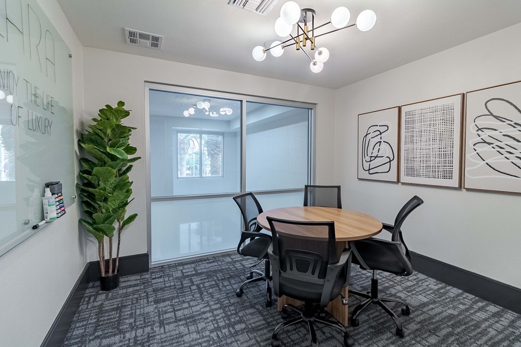 A conference room with a table, chairs, and artwork on the wall.