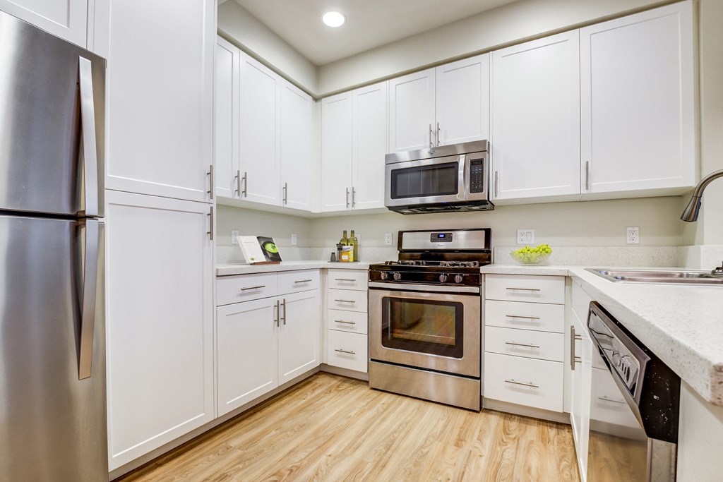 Apartments in Milpitas, CA with In-Unit Washer and Dryer - Ilara Apartments - Kitchen with Modern White Cabinets, Stainless Steel Appliances, and a Breakfast Bar
