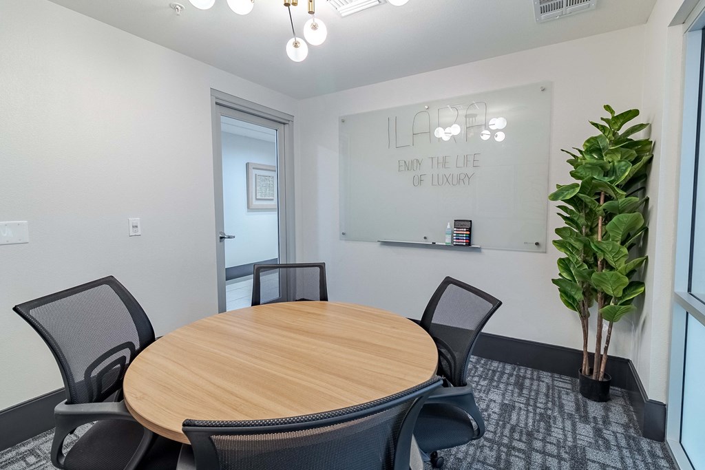 a conference room with a round table and a large potted plant