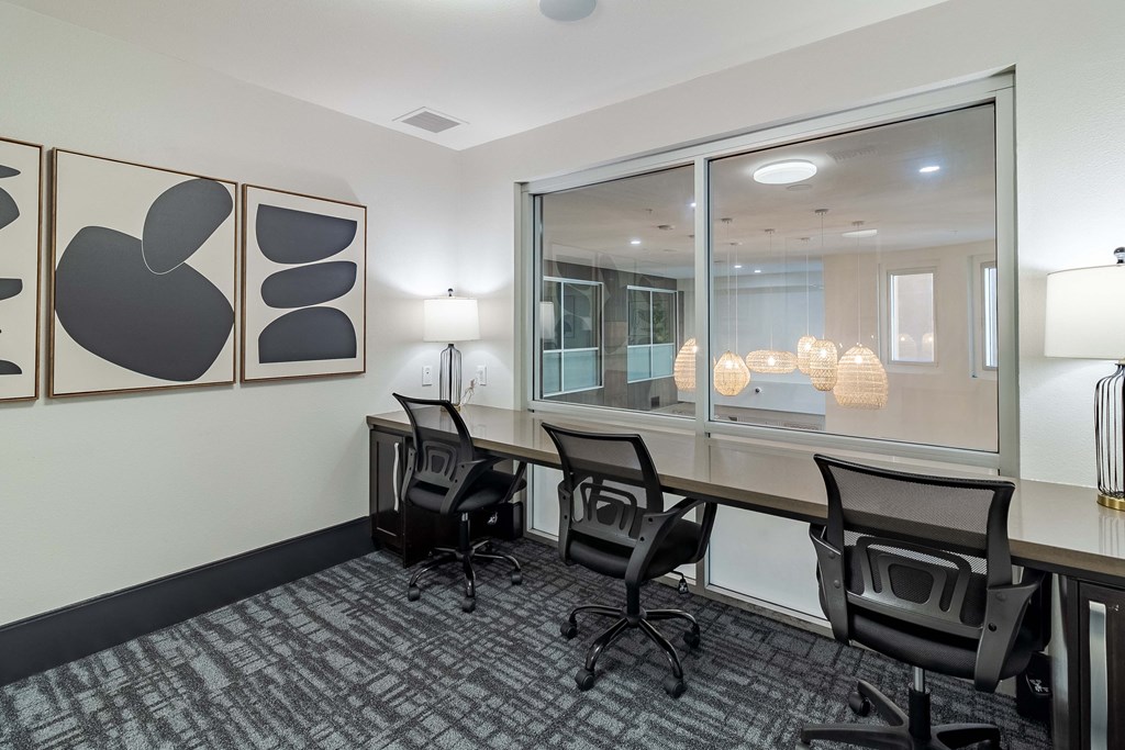 a conference room with a desk and chairs and a window