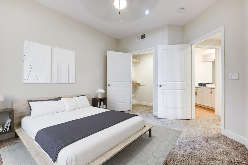 A bedroom with a large bed and a carpeted floor.