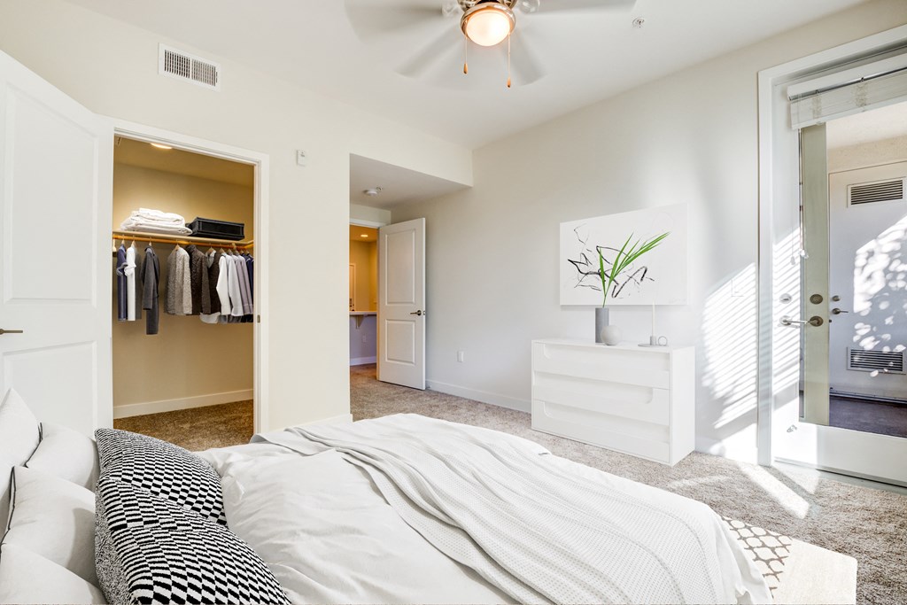 Dog-Friendly Apartments in Milpitas, CA - Ilara Apartments - Bedroom with Soft Carpet, a Ceiling Fan, and a Spacious Closet