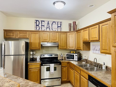 a kitchen with wooden cabinets and stainless steel appliances