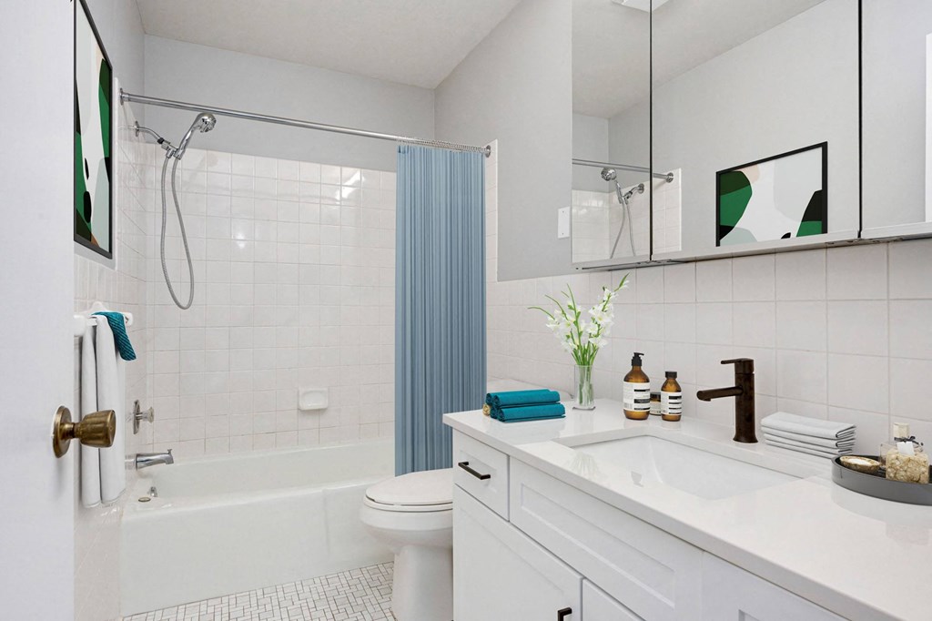 Laurel West End Apartments in Golden Valley, MN photo of a bathroom with white tiles and a blue shower curtain