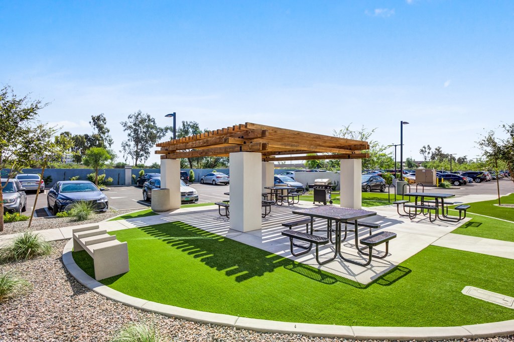 Downtown Phoenix, AZ Apartments - Imperial - Outdoor Community BBQ Area with Picnic Tables and a Grill Under a Pergola