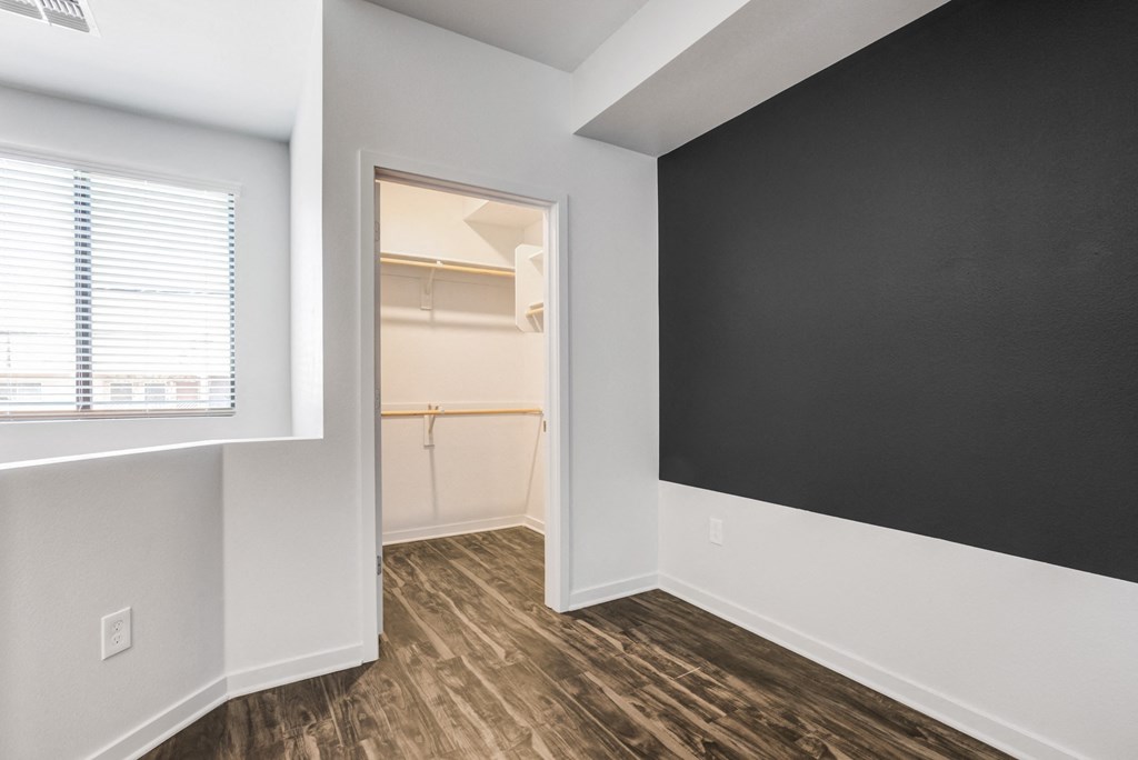 an empty room with a black wall and a closet