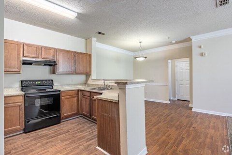 A kitchen with wooden cabinets and a black oven.