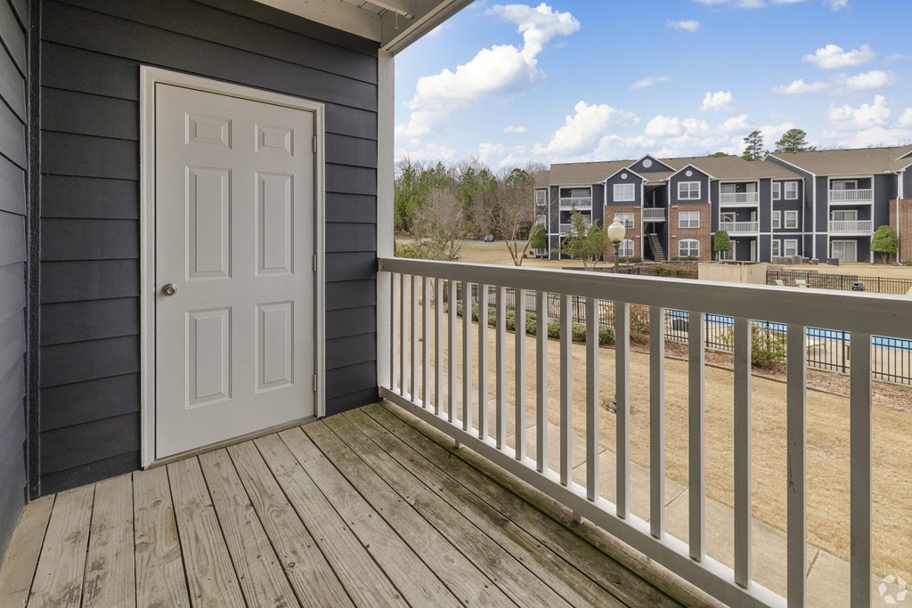 Pet-Friendly Rentals in Little Rock, AR – Capitol Hill – A balcony with a white door and a view of apartment buildings.