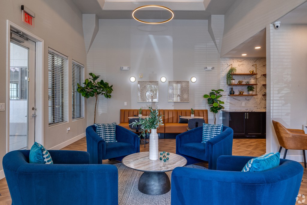 A living room with blue chairs and a white ceiling.