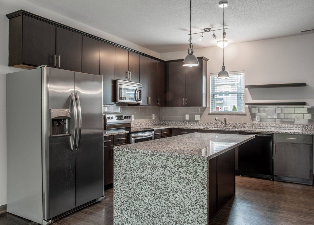 a kitchen with a large island and stainless steel appliances