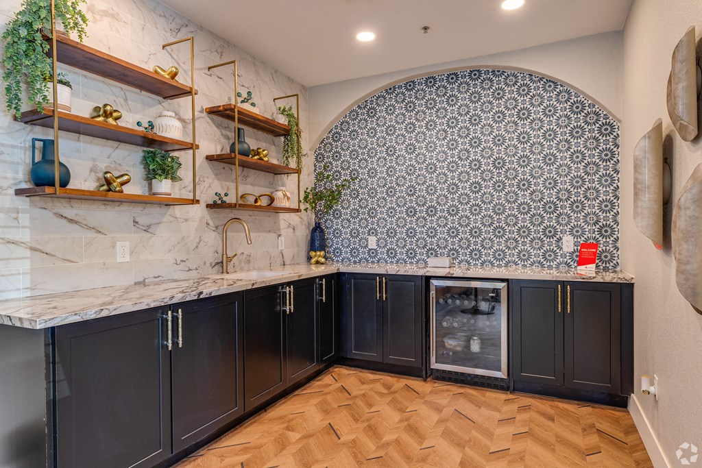A kitchen with black cabinets and a marble countertop.