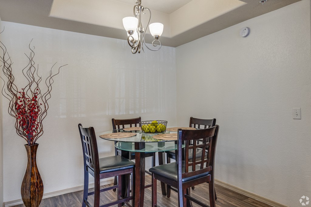 A dining room with a glass table and chairs.