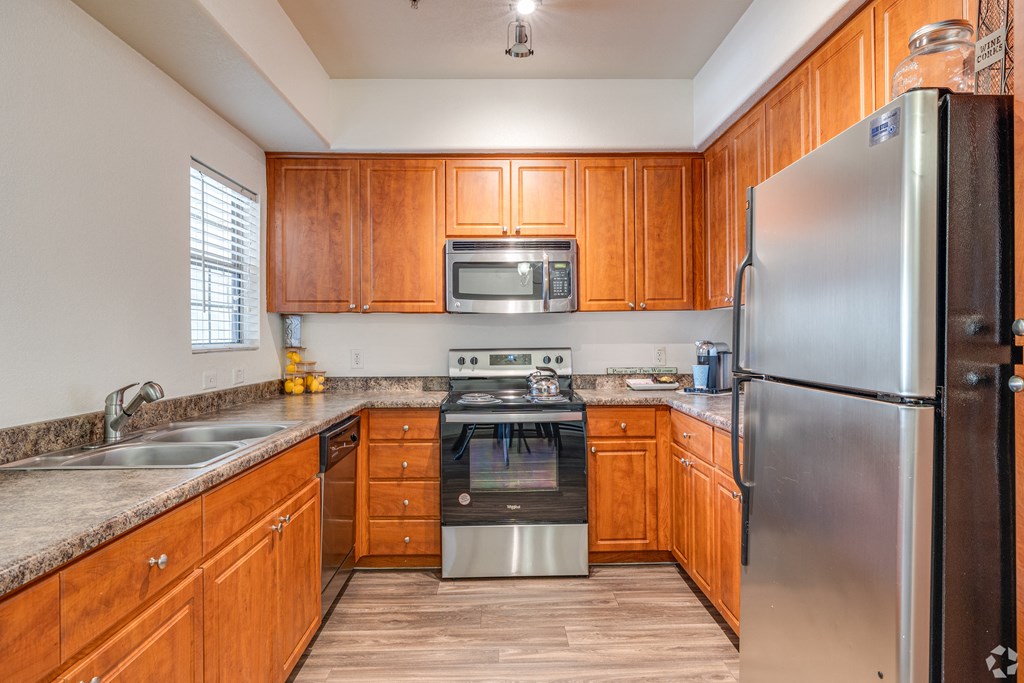 A kitchen with wooden cabinets and stainless steel appliances.