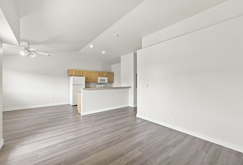 A kitchen area with a wooden island and a ceiling fan.