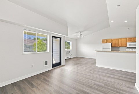 A spacious kitchen with a white countertop and wooden cabinets.
