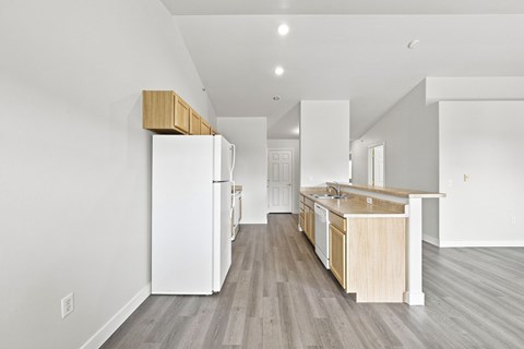 A kitchen with a white refrigerator and wooden cabinets.